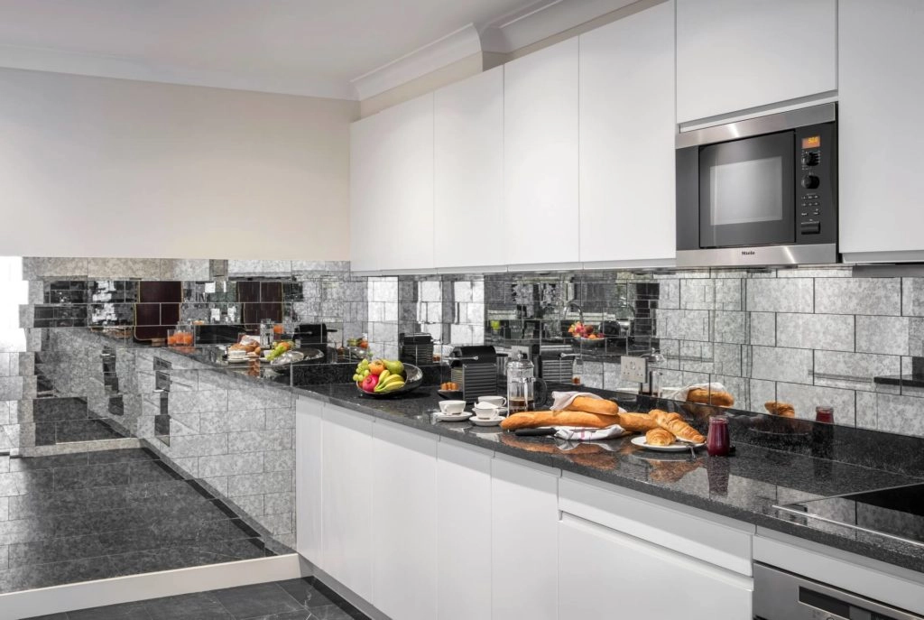 Spacious modern kitchen with sleek appliances, fresh pastries, and vibrant fruits, offering a luxurious Arlington House stay.