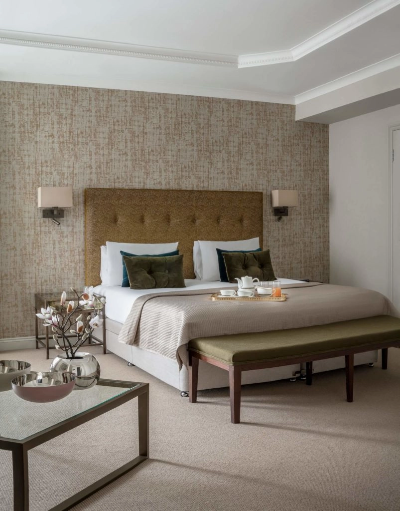 Elegant hotel bedroom with plush bed, stylish headboard, and cosy decor at Arlington House Apartments. Perfect for relaxation.