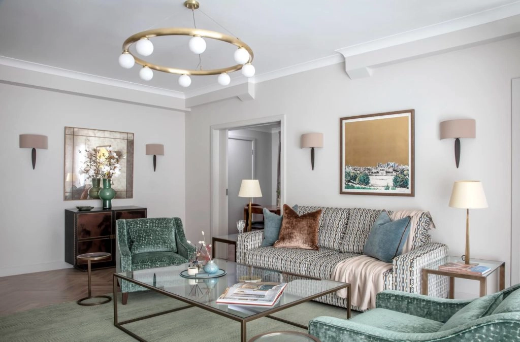 Elegant living room with plush sofa, chic armchairs, and modern lighting in Arlington House Apartments, London.
