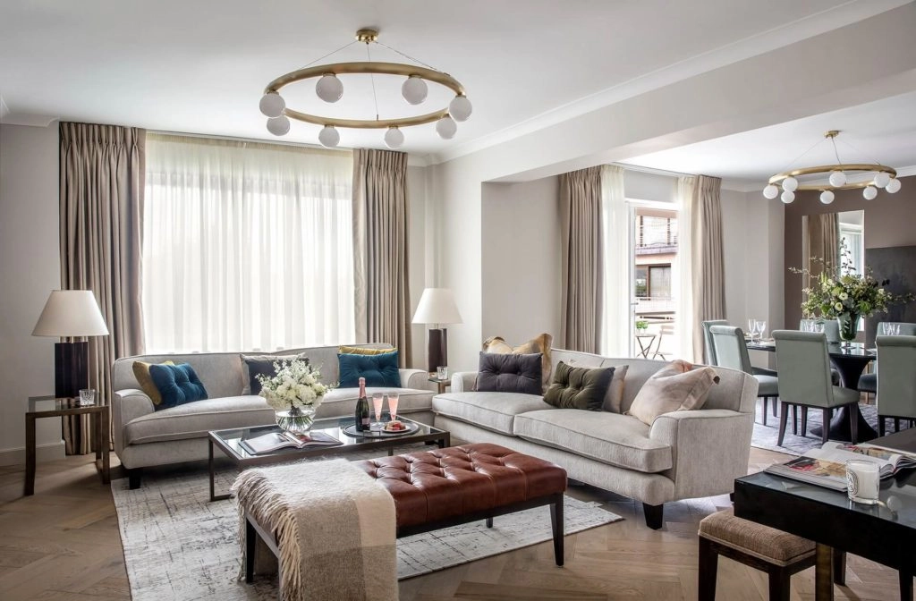 Spacious living area in Arlington House Apartments with elegant sofas, chic lighting, and a dining setup for serene stays.