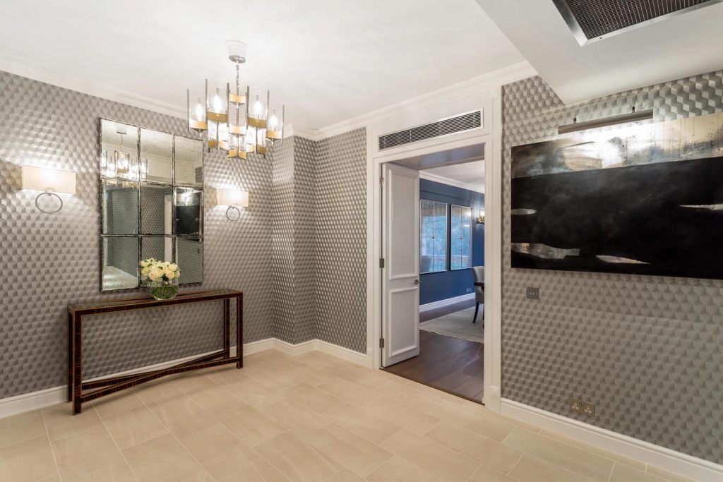 Elegant Arlington House hallway, featuring stylish lighting, textured walls, and an open door to a cosy lounge.