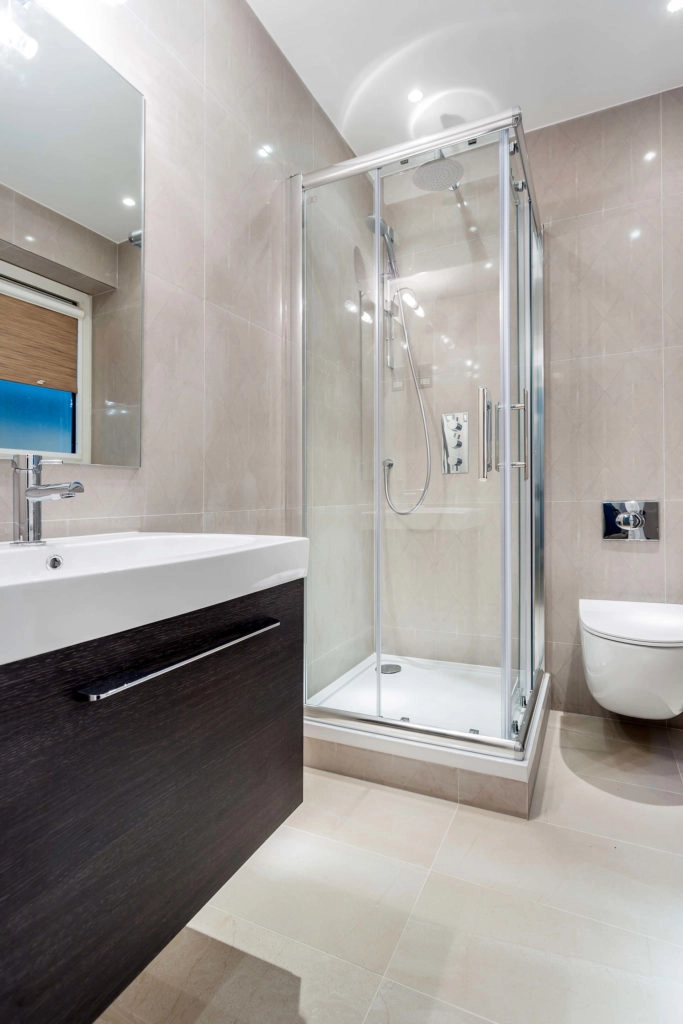 Elegant bathroom with modern glass shower, sleek vanity, and warm lighting at Arlington House Apartments.