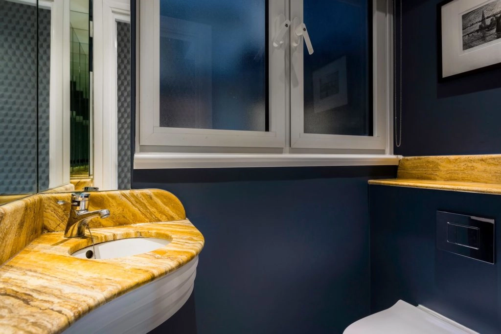 Elegant bathroom with sleek sink, warm lighting, and modern design at Arlington House Apartments for a relaxing stay.