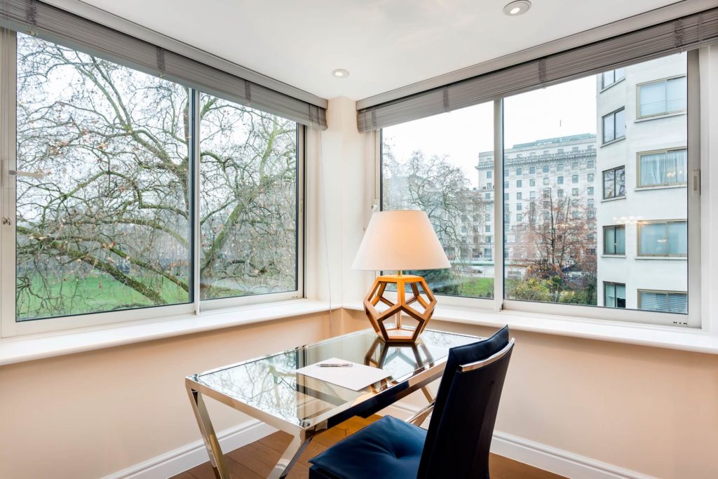 Enjoy scenic city and park views from a luxurious Arlington House Apartments desk space with modern decor and ample natural light.