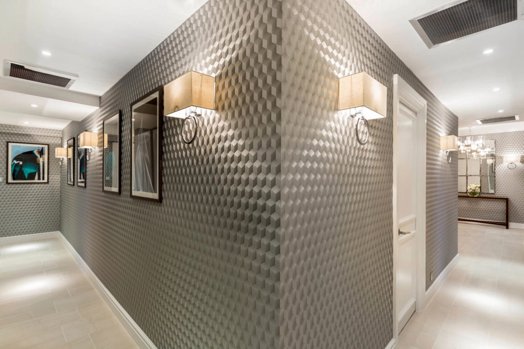 Elegant, textured hotel corridor with modern lighting and framed art in Arlington House Apartments.