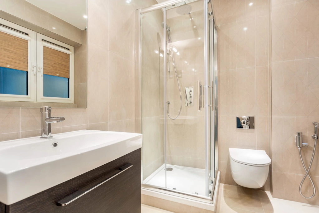 Elegant Arlington bathroom with modern shower, sleek basin, and large mirror; perfect for a relaxing stay in London.