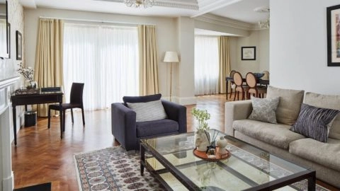 Elegant living area with modern decor, plush sofas, a stylish dining table, and natural light at Arlington House Apartments.