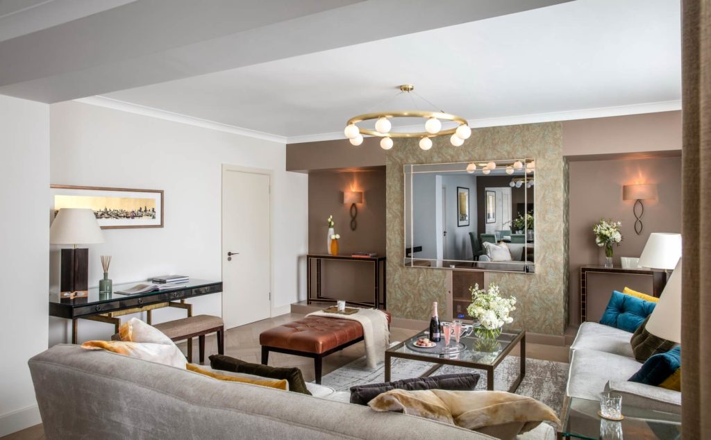 Elegant living area with plush sofas, ambient lighting, stylish decor, and a glass coffee table in Arlington House Apartments.