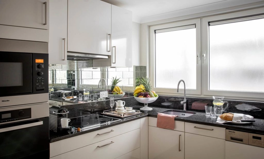 Modern kitchen with sleek appliances, fruit bowl, and dining set; inviting and well-equipped space in Arlington House Apartments.
