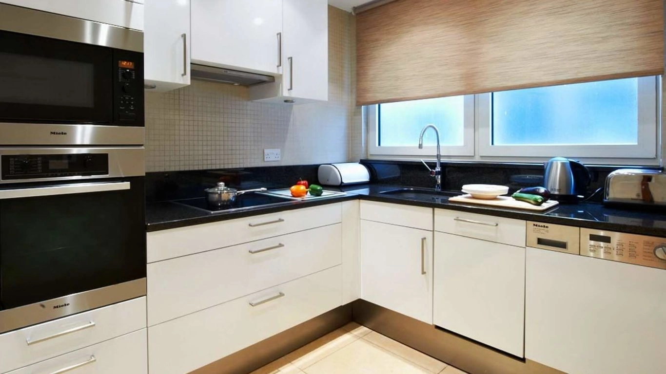 Modern kitchen with sleek cabinets, oven, and stainless steel appliances at Arlington House Apartments, ideal for self-catering stays.