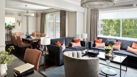 Modern Arlington House living room with plush sofas, elegant dining area, large window view, and stylish decor.