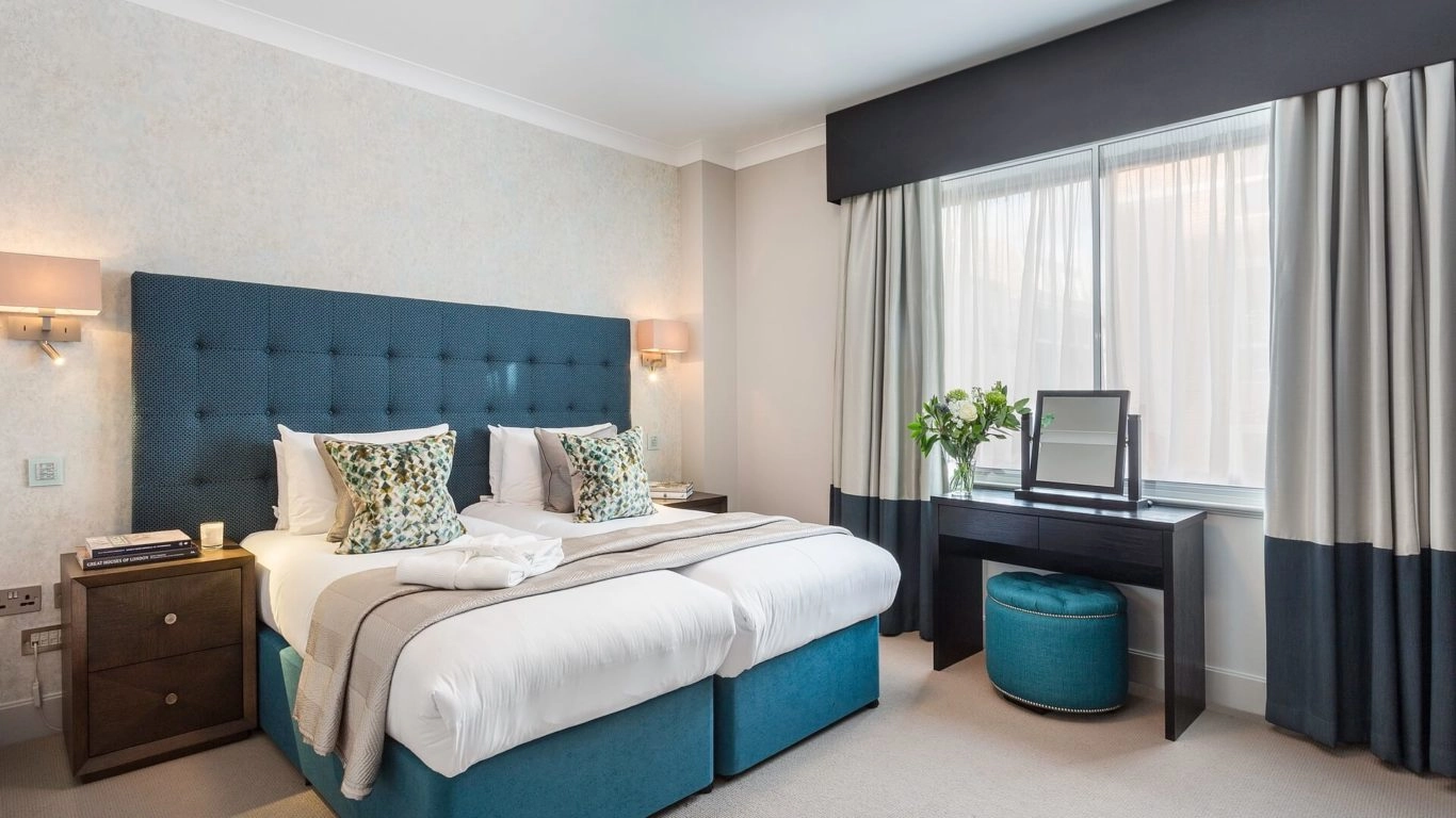 Elegant bedroom with plush double bed, stylish decor, natural light, and modern amenities at Arlington House Apartments.