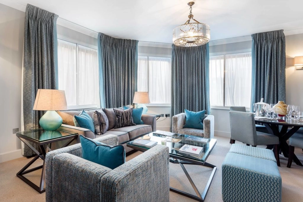 Stylish living room at Arlington House Apartments with plush sofas, modern decor, and elegant dining area for relaxation.